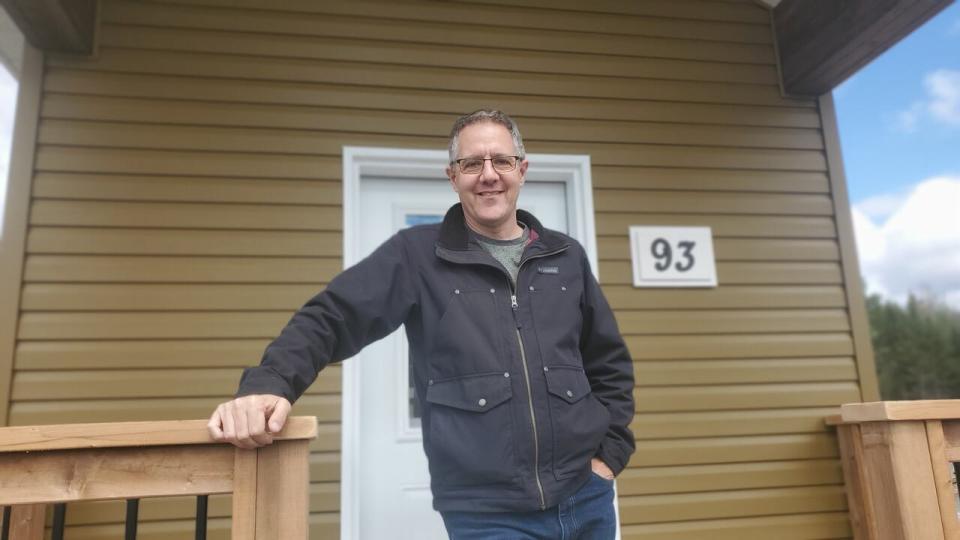 Marcel LeBrun stands at the entrance of the final tiny home installed in the community of 12 Neighbours.