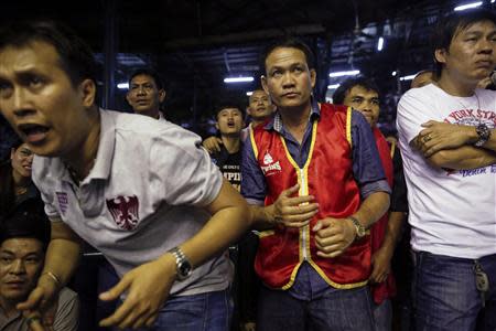 Thai boxing team members from the red corner follow their fighter during the closing Thai boxing, or "Muay Thai", fight night of the legendary Lumpinee stadium, one of Bangkok's oldest boxing venues which is being demolished after 57 years February 7, 2014. REUTERS/Damir Sagolj