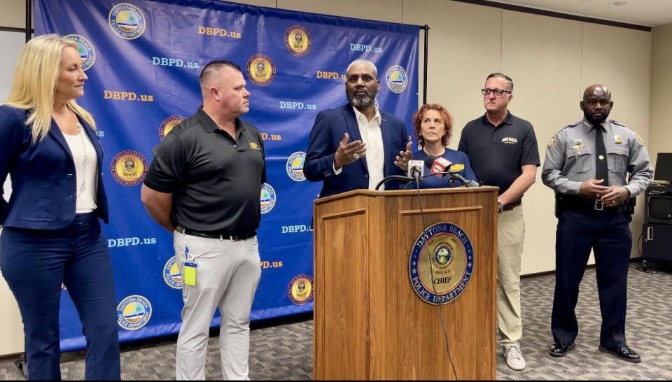 Sherman Patterson (at the microphone), vice-president of Lights On, explains at a Thursday press conference that his nonprofit allows police officers to give vouchers instead of tickets for non-working lights, and helps heal police-community relations.