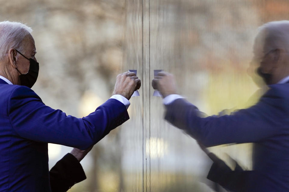 President Joe Biden and first lady Jill Biden make a tracing of Cpl. Dennis F. Shine's name at the Vietnam Veterans Memorial in honor of Vietnam War Veterans Day on Monday, March 29, 2021, in Washington. (AP Photo/Evan Vucci)