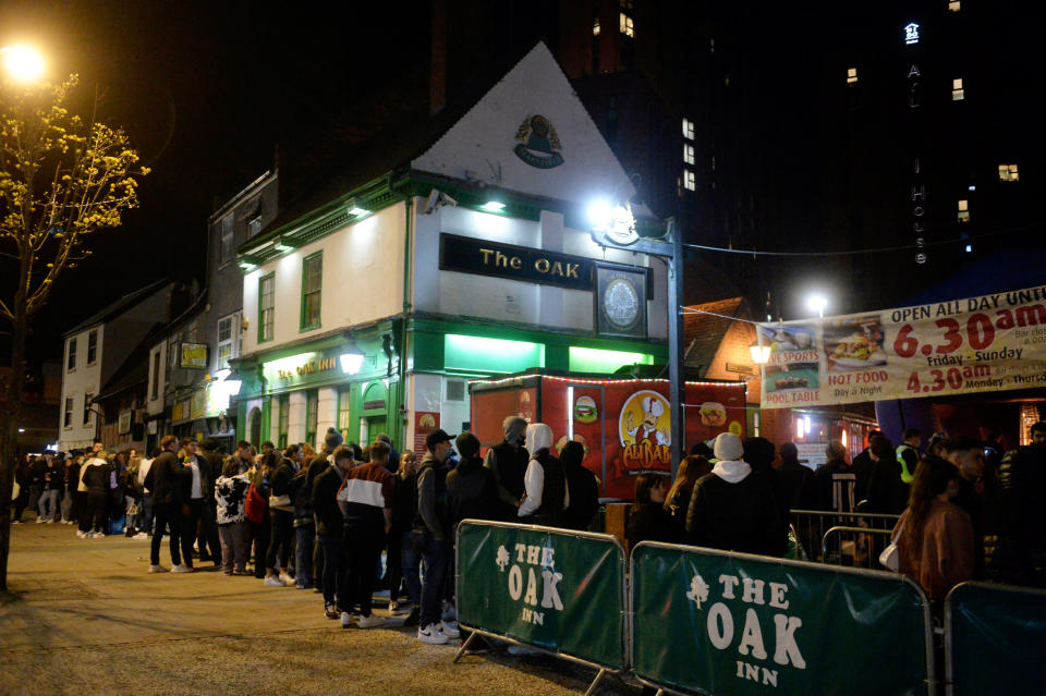 People queueing outside The Oak Inn in Coventry, hoping to enjoy their first post-lockdown pints mere moments after midnight as restrictions across the UK are partially eased. The establishment is licensed till 6am, and also plans to sell food throughout the night, such as pizzas, burgers and kebabs. April 11 2021.
