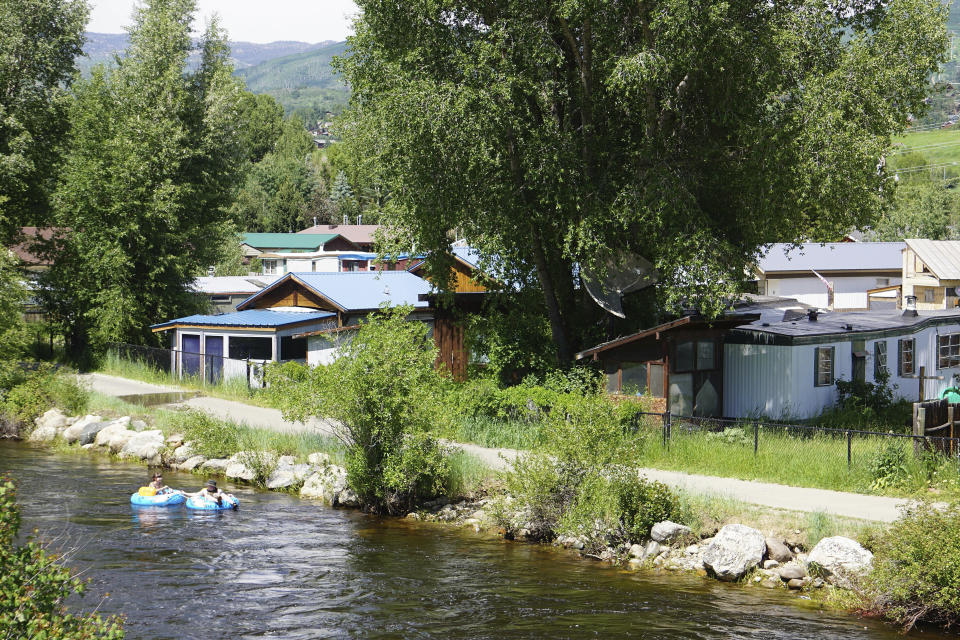 This July 6, 2019, photo shows the Fish Creek Mobile Home Park next to the Yampa River and bike path in Steamboat Springs, Colo. Some Colorado towns are taking action to preserve their remaining mobile home parks. Cities, counties and housing authorities, such as the Yampa Valley Housing Authority in Steamboat Springs, are buying mobile home parks to preserve affordable housing for residents as other mom-and-pop park owners sell out to developers or investors.(Matt Stensland/The Colorado Sun via AP)