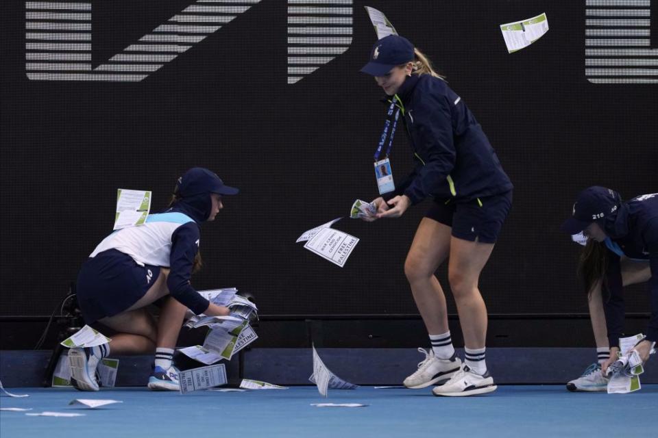 澳網球僮清理抗議傳單。（美聯社）