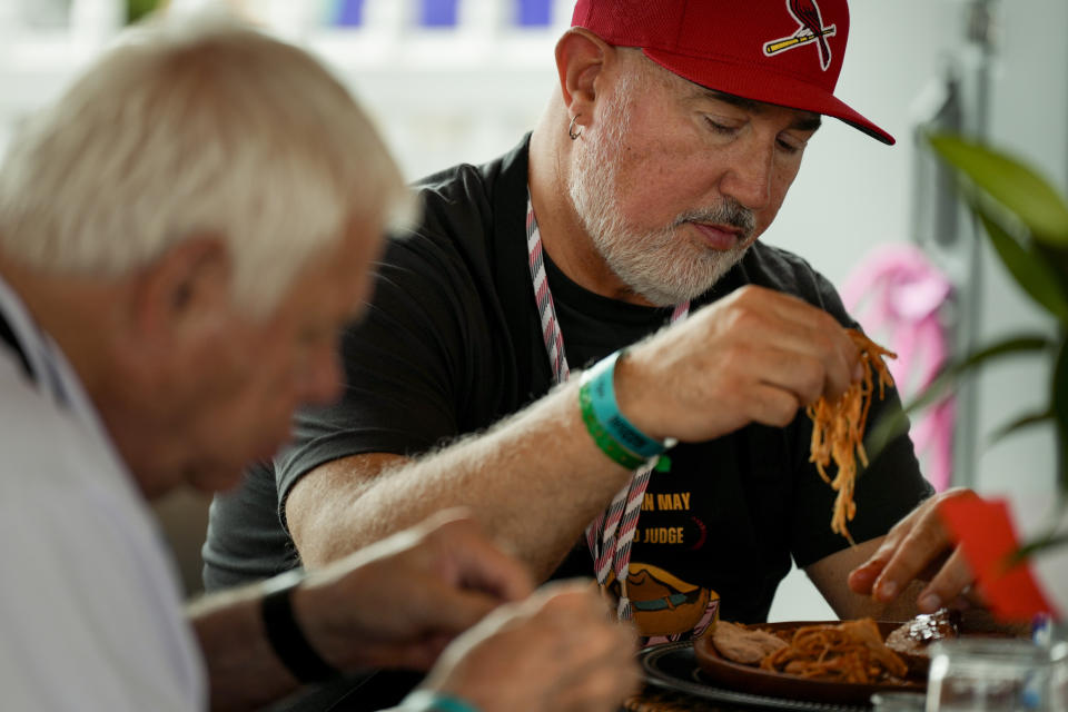 Judge Shawn Dank, right, tastes a piece of whole hog from the Pig Diamonds BBQ Team at the World Championship Barbecue Cooking Contest, Saturday, May 18, 2024, in Memphis, Tenn. (AP Photo/George Walker IV)