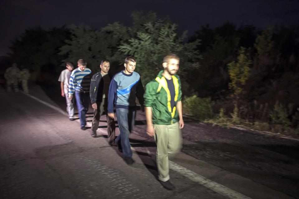 Members of the Ukrainian government forces, who are prisoners-of-war, walk along a road as they wait to be exchanged, north of Donetsk, eastern Ukraine