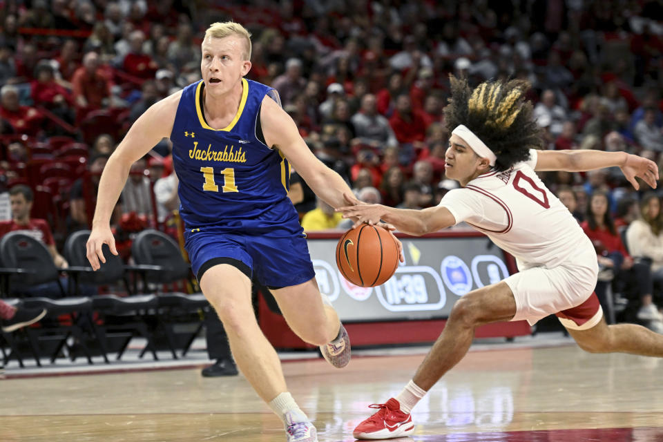 Arkansas guard Anthony Black (0) steals the ball from South Dakota State forward Matthew Mors (11) as he tries to drive to the basket during the first half of an NCAA college basketball game Wednesday, Nov. 16, 2022, in Fayetteville, Ark. (AP Photo/Michael Woods)