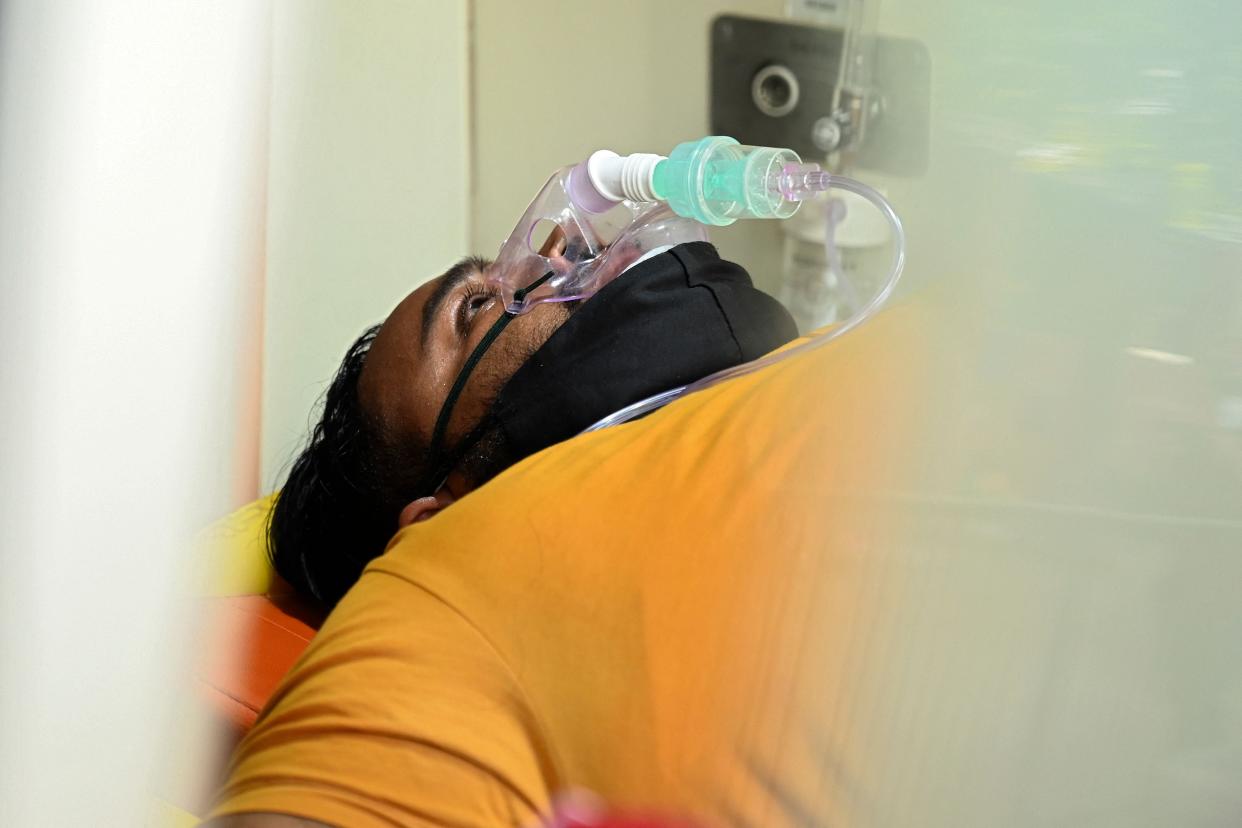 A Covid-19 coronavirus patient lies in an ambulance upon his arrival at a hospital in New Delhi on 1 May, 2021.  (AFP via Getty Images)