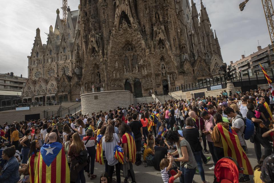 Demonstrators join a pro-independence gathering outside the Sagrada Família basilica during the fifth day of protests over the conviction of a dozen Catalan independence leaders in Barcelona, Spain, Friday, Oct. 18, 2019. Various flights into and out of the region are cancelled Friday due to a general strike called by pro-independence unions and five marches of tens of thousands from inland towns are expected converge in Barcelona's center on Friday afternoon for a mass protest with students to and workers who are on strike. (AP Photo/Bernat Armangue)