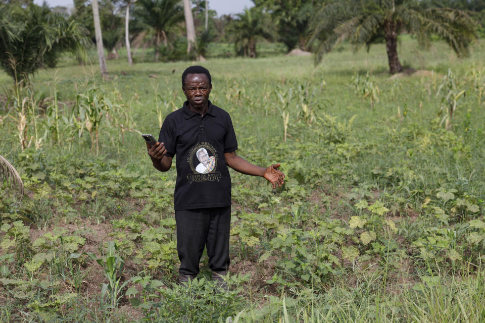 Cyril Fianyo, a farmer and a beneficiary under the Uniti Networks project, holds the phone he uses to check the weather and learn about agricultural practices at his farm in Atabu, Hohoe, in Ghana's Volta region, Wednesday, April 18, 2024. Uniti Networks offers financing to help make smartphones more affordable and coaches users to navigate its platform of apps. For Fianyo, who previously planted according to his intuition and rarely interacts with farming advisors, the phone has expanded his activities beyond calls and texts. “I will know the exact time to plant because of the weather forecast,” he said. (AP Photo/ Misper Apawu)