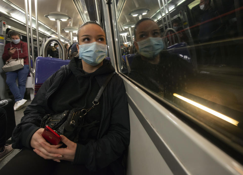 Livia Bulcao stares out of the window of a Paris Metro train on her morning commute through the French capital on May 18, 2021. The 23-year-old was traveling in Australia when the pandemic hit in 2020 and was repatriated on a government flight back to France, where she moved back in with her parents in Montmartre, Paris, and found work. "Living here is a bit like a step back for me. But it's not the death of me. There are far worse things in life," she says. (AP Photo/Joao Luiz Bulcao)