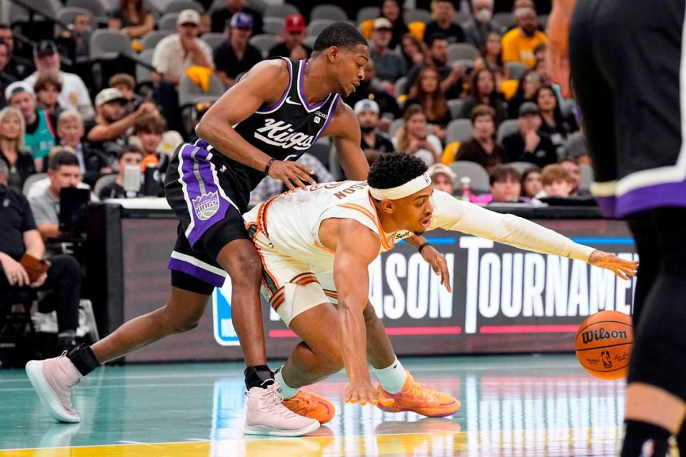 Sacramento Kings guard De’Aaron Fox (5) and and San Antonio Spurs forward Keldon Johnson (3) battle for the loose ball during the first half Friday, Nov. 17, 2023, at Frost Bank Center in San Antonio, Texas.