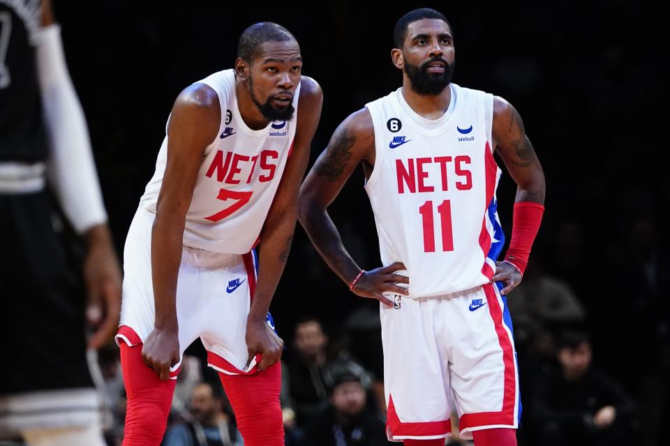 Brooklyn Nets' Kevin Durant (7) talks to Kyrie Irving (11) during the second half of an NBA basketball game against the San Antonio Spurs, Monday, Jan. 2, 2023, in New York. The Nets won 139-103. (AP Photo/Frank Franklin II)