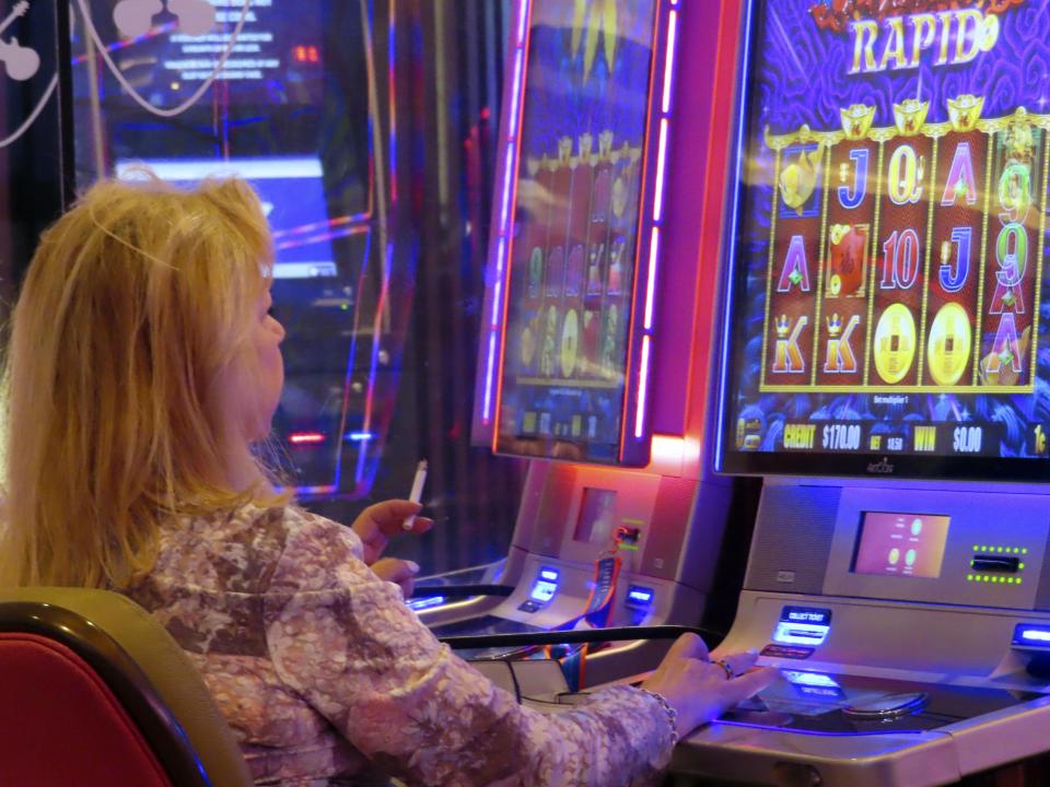 A gambler smokes while playing a slot machine at the Hard Rock casino in Atlantic City N.J. on Aug. 8, 2022. On Monday Feb. 13, 2023, lawmakers will hold their first hearing on a bill that would ban smoking in Atlantic City's nine casinos. (AP Photo/Wayne Parry)