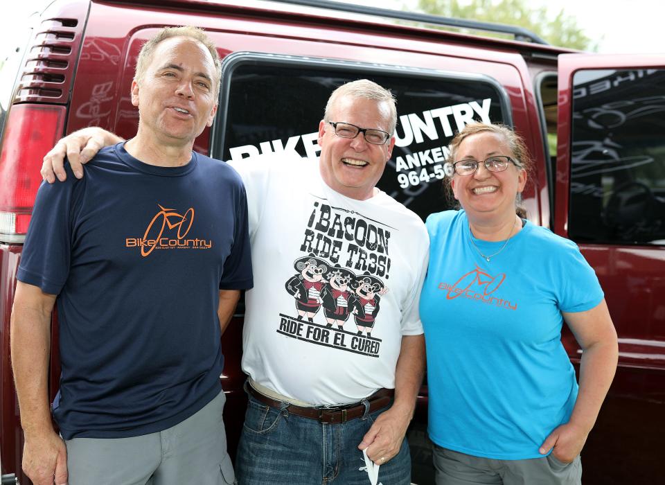 Don Brown, center, of Ankeny stops by for a picture with Leanne and Gordon Havlik of Bike Country of Ankeny during the BACooN Sizzles Waukee party as guests celebrate at Centennial Park in Waukee on Friday, June 14, 2019, on the eve of the BACooN Ride 6.