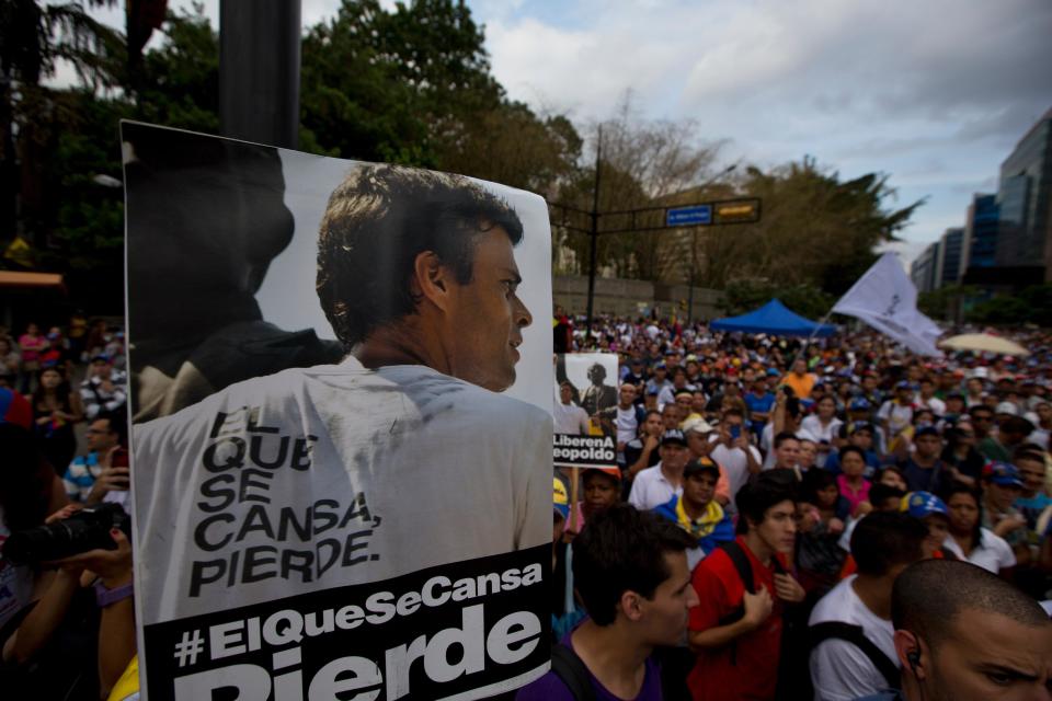 Manifestantes alzan en primer plano un poster con el retrato del líder opositor Leopoldo López cuya libertad están demandando en una nueva protesta en Caracas, Venezuela, el viernes 4 de abril de 2014. (AP Photo/Fernando Llano)