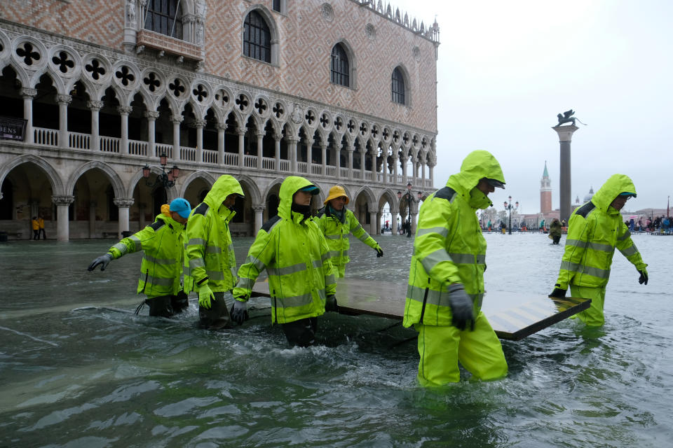 Workers are seen in the flooded St.Mark's Square during a period of seasonal high water in Venice, Italy November 12, 2019. REUTERS/Manuel Silvestri