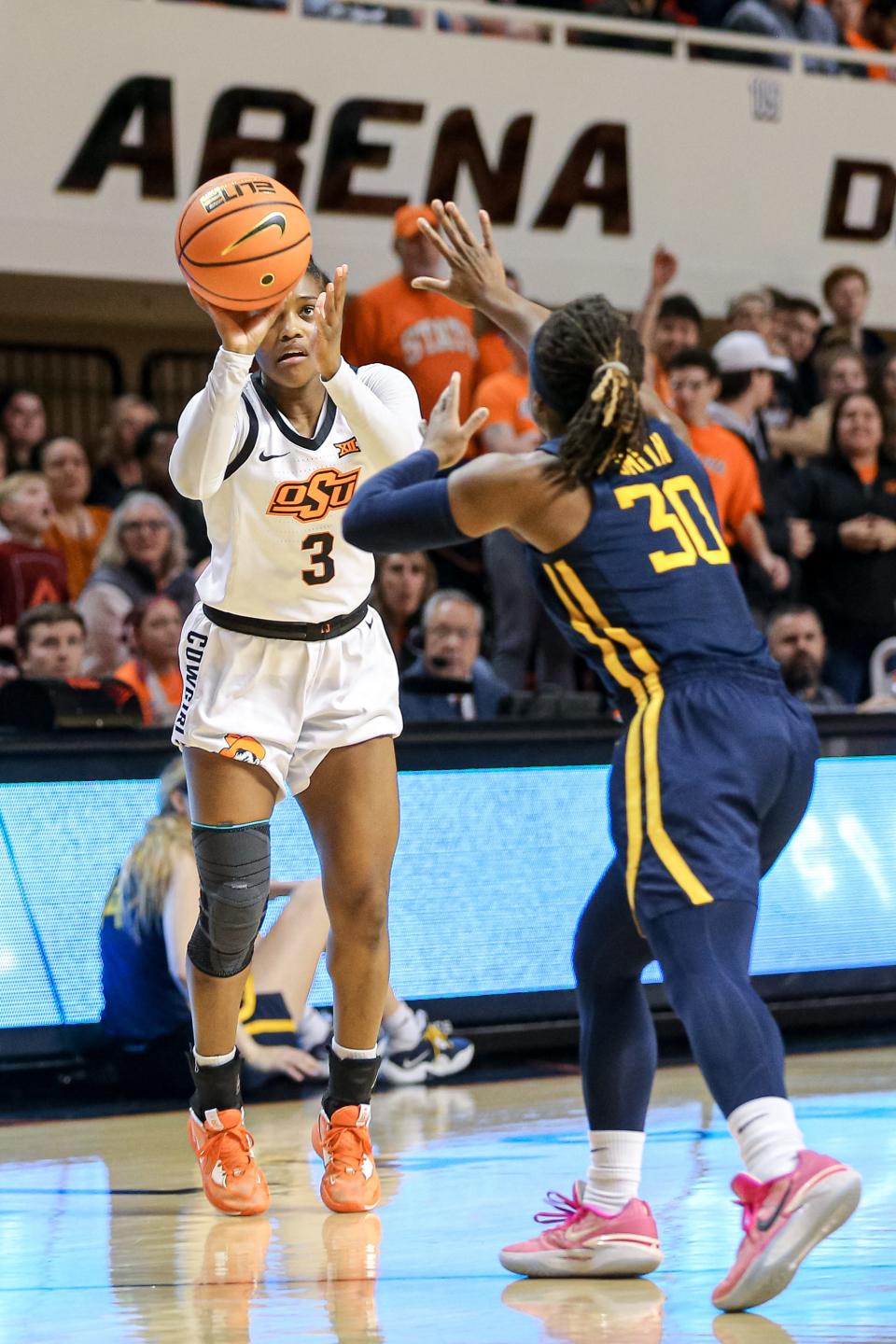 Oklahoma State guard Naomie Alnatas (3) shoots for three over West Virginia guard Madisen Smith (30) in the first half during a women’s college basketball game between the Oklahoma State Cowgirls (OSU) and the West Virgina Mountaineers at Gallagher-Iba Arena in Stillwater, Okla., on Tuesday, Feb. 7, 2023.