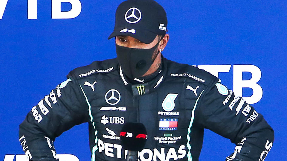 Lewis Hamilton (pictured) during an F1 award ceremony with his hands on his hips.