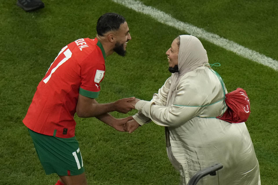 El volante marroquí Sofiane Boufal (izquierda) celebra con su madre tras la victoria 1-0 ante Portugal en los cuartos de final del Mundial, el sábado 10 de diciembre de 2022, en el estadio Al Thumama, en Doha, Qatar. (AP Foto/Alessandra Tarantino)