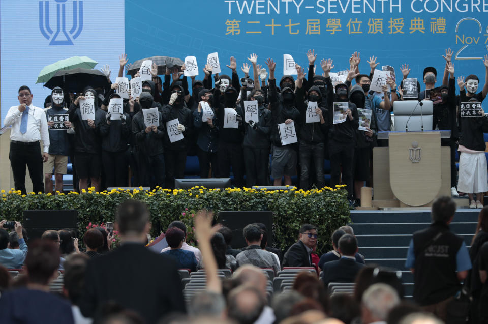 Protesters occupy the stage to briefly delay a graduation ceremony during an anti-government rally at the Hong Kong University of Science and Technology, Thursday, Nov. 7, 2019, in Hong Kong. (AP Photo/Dita Alangkara)