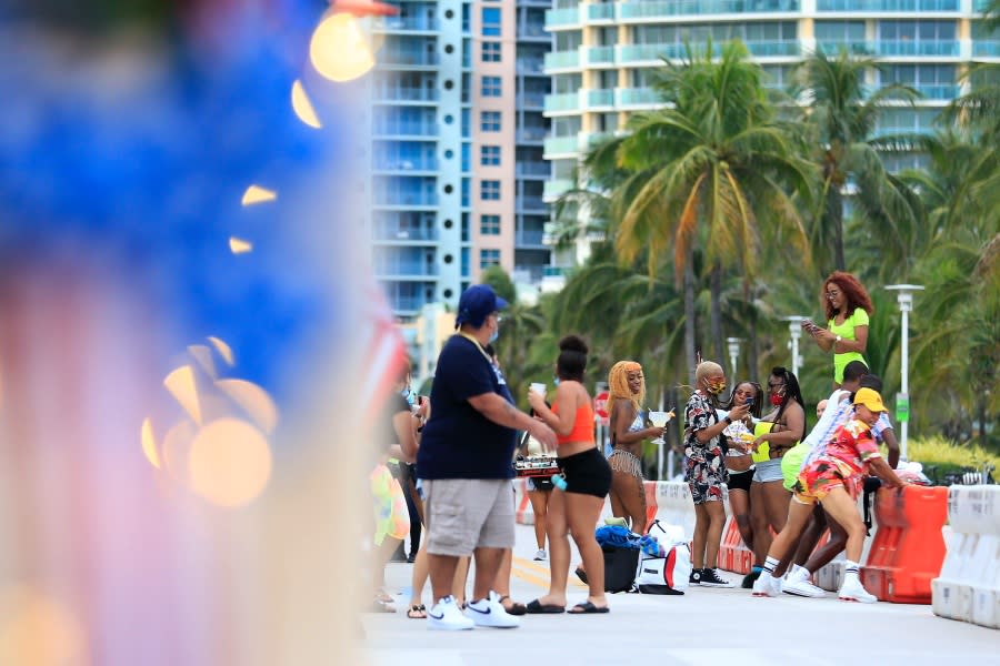 People dance on the street on July 03, 2020 in the South Beach neighborhood of Miami Beach, Florida. In order to prevent the spread of COVID-19, Miami-Dade county has closed beaches from July 3-7 and imposed a curfew from from 10pm to 6am in preparation for the July 4th holiday weekend. (Photo by Cliff Hawkins/Getty Images)