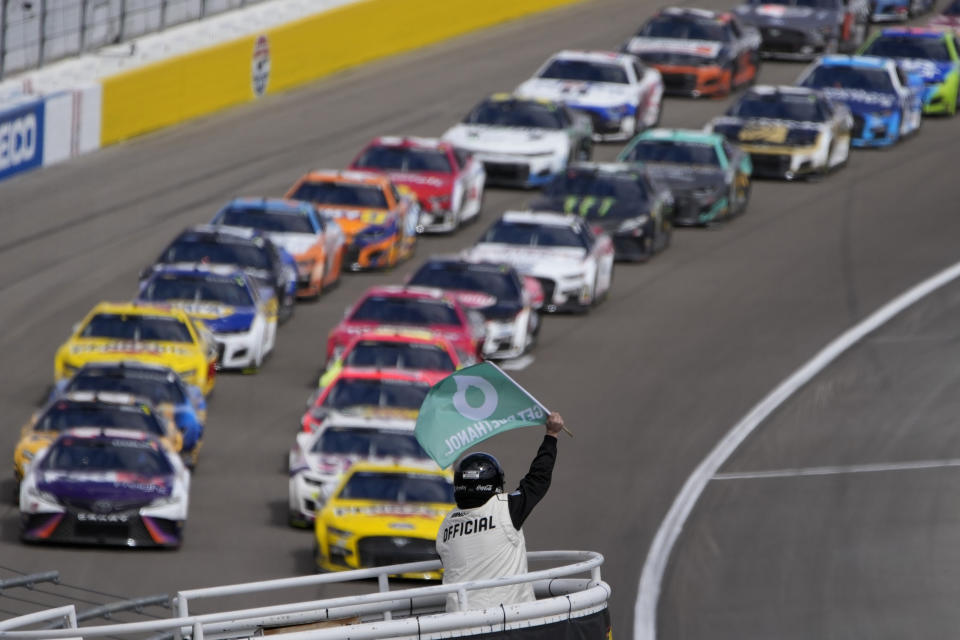 An official restarts the race after a caution flag during a NASCAR Cup Series auto race Sunday, March 6, 2022, in Las Vegas. (AP Photo/John Locher)