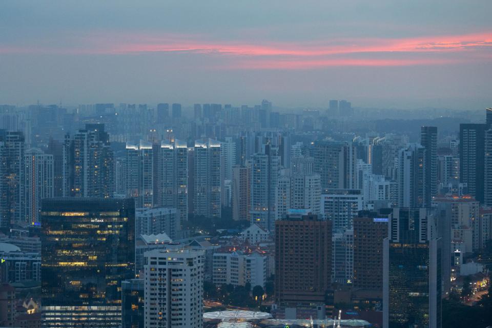 Commercial and residential buildings stand at dusk in Singapore, on Wednesday, June 13, 2018. Tourism as well as the consumer sector will likely see a lift thanks to the influx of international media at the recent DPRK-USA Summit, according to RHB Research Institute Singapore Pte. Photographer: Brent Lewin/Bloomberg