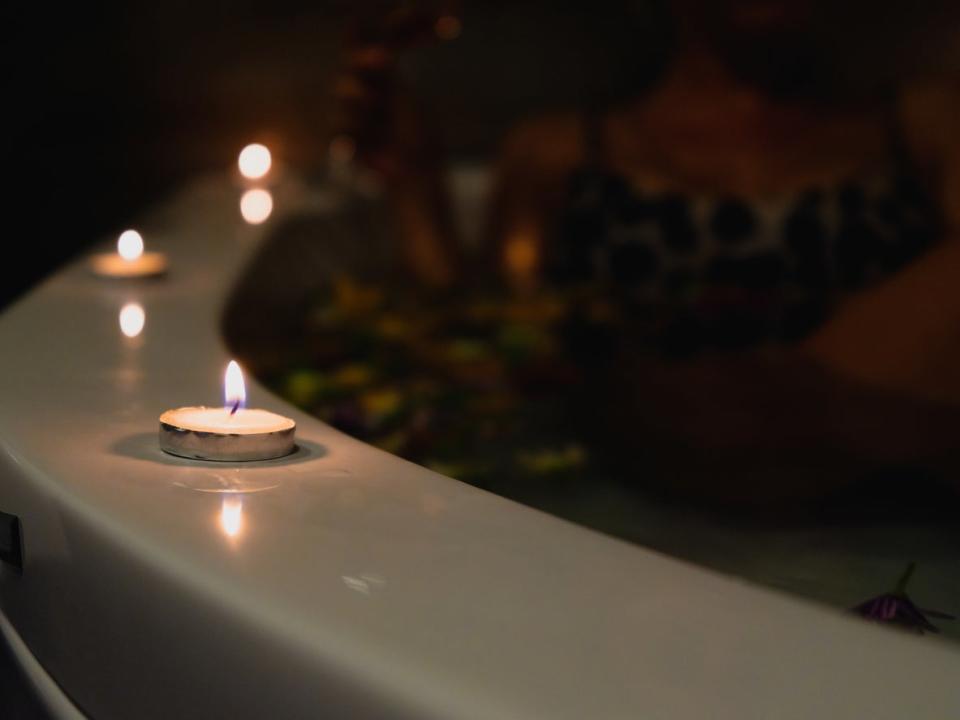 Three lit tealight candles on the edge of a hot tub.