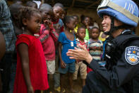 Inspector Second Class Zhang Ying, a female member of the Chinese Formed Police Unit (FPU) deployed at UN Mission in Liberia (UNMIL), interacts with a girl of the Steward Camp in Tubmanburg, during a long-range patrol, Liberia February 1, 2018. Albert Gonzalez Farran/UNMIL/Handout via REUTERS