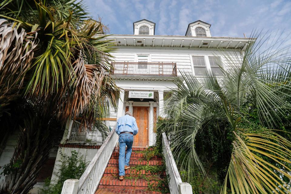 Bill Barton walks up the stairs to the entrance of the Butler Island house in Darien, Georgia.