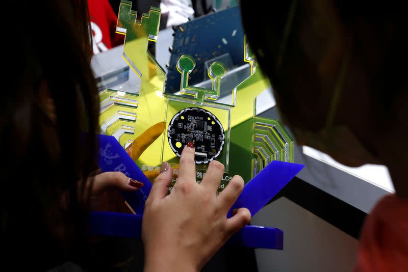 Guide introduces a chip to students on tour at the Science park exploration museum in Hsinchu,