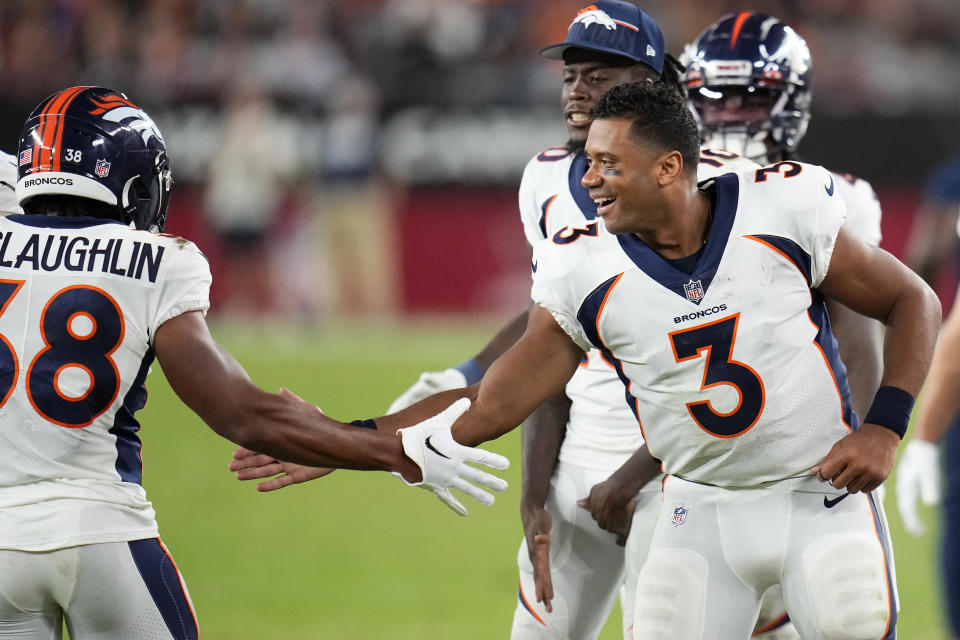 Denver Broncos running back Jaleel McLaughlin, left, is congratulated by quarterback Russell Wilson (3) after scoring against the Arizona Cardinals during the second half of an NFL preseason football game in Glendale, Ariz., Friday, Aug. 11, 2023. (AP Photo/Ross D. Franklin)