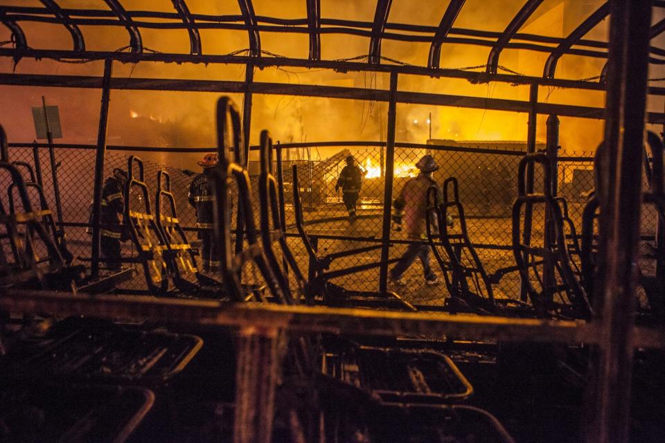 WASHINGTON, USA - APRIL 27: Fire Fighter attempt to put out a building that was set on fire during riots in Baltimore, USA on April 27, 2015. Protests following the death of Freddie Gray from injuries suffered while in police custody have turned violent with people throwing debris at police and media and burning cars and businesses. (Photo by Samuel Corum/Anadolu Agency/Getty Images)