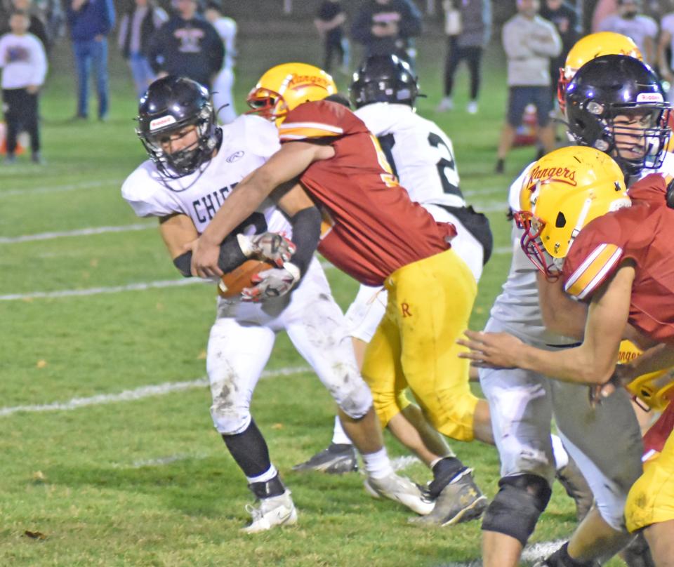 Reading linebacker Joey Campbell (52) bursts into the backfield to tackle White Pigeon's Dominic Fraschetti (12) for a loss Friday night in District finale action.