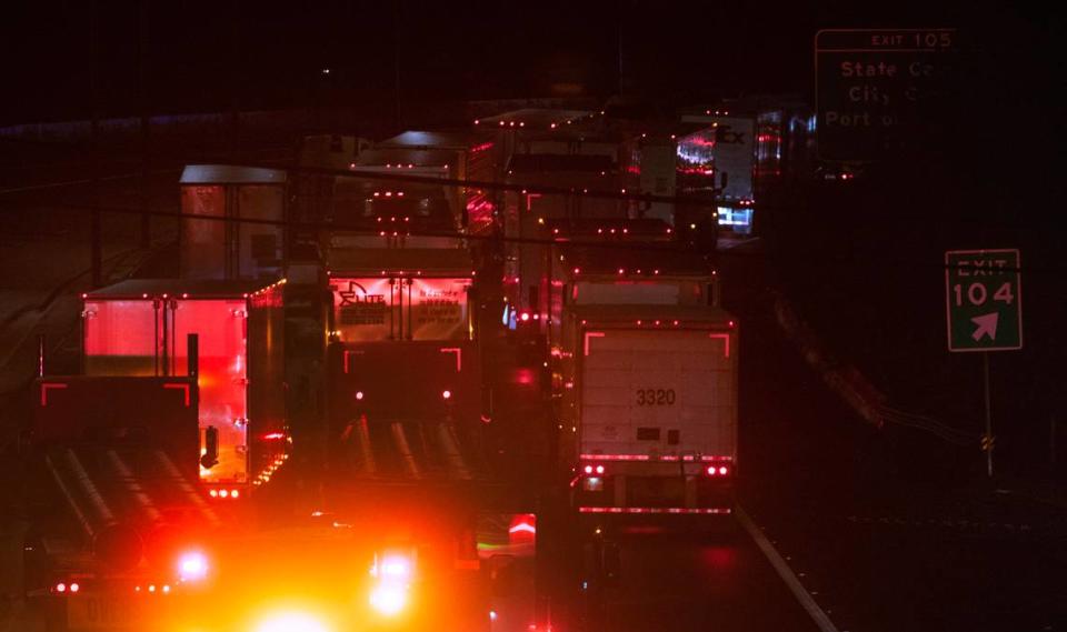 Trucks are stuck on northbound Interstate 5 as crews worked to clear an overturned tractor-trailer on southbound freeway at the Highway 101 interchange in Tumwater, Washington, late on Monday, Oct. 16, 2023. Tony Overman/toverman@theolympian.com