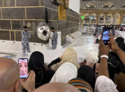 Muslim pilgrims film the Black Stone located on the Kaaba, the cubic building at the Grand Mosque, in the Saudi Arabia's holy city of Mecca, Tuesday, July 5, 2022. Saudi Arabia is expected to receive one million Muslims to attend Hajj pilgrimage, which will begin on July 7, after two years of limiting the numbers because coronavirus pandemic. (AP Photo/Amr Nabil)