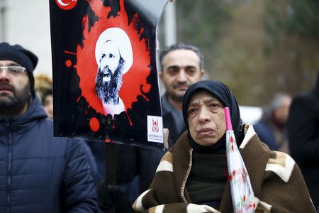 A shi'ite protester holds an image of Sheikh Nimr al-Nimr during a demonstration in front of Saudi Arabia's Consulate in Istanbul, Turkey, January 3, 2016. REUTERS/Osman Orsal