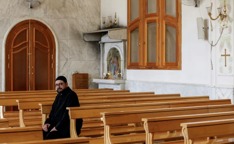 Father Thomas Kassuha sits in the St. Elias Syriac Orthodox church in the Syrian village of Fairouzah on July 13, 2018