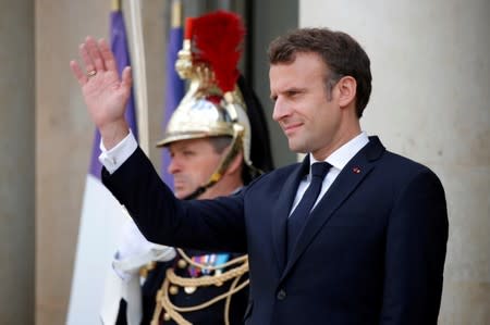 French President Emmanuel Macron waves at the Elysee Palace in Paris