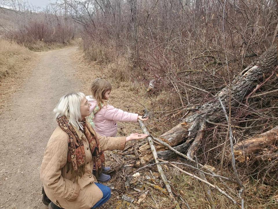 U of A masters student Stephanie Olsen feeds the chickadees at Edmonton's Rundle Park with her niece.