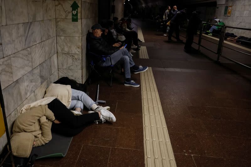 People take shelter inside a metro station during a Russian military attack, in Kyiv