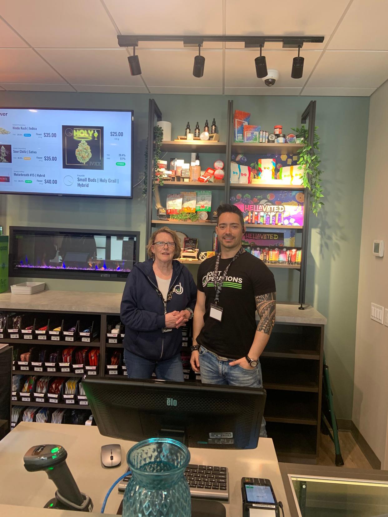Susan Lee-Waite, a budtender, and Daniel Lencioni, district manager, welcome customers to the first day of operations a Joint Operations at Timpany Crossroads in Gardner. The city's second recreational marijuana dispensary opened on Sunday, 4/21.