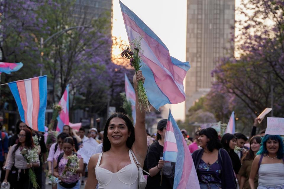 People, some holding transgender flags, take part in a march celebrating International Transgender Day of Visibility, in Mexico City, Friday, March 31, 2023.