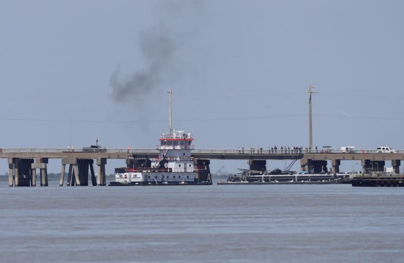 A tugboat works to maneuver a barge away from the Pelican Island Bridge in Galveston, Texas, on Wednesday, May 15, 2024, after the barge crashed into the bridge shutting down the only road access to and from the island. (Jennifer Reynolds/The Galveston County Daily News via AP)