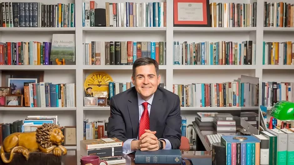 Russell Moore, editor in chief of Christianity Today magazine, sits at a desk with bookshelves behind him.