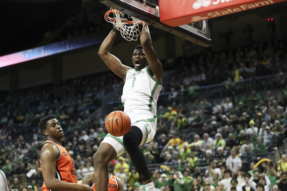 Oregon center N'Faly Dante (1) dunks next to Oregon State center KC Ibekwe during the first half of an NCAA college basketball game Wednesday, Feb. 28, 2024, in Eugene, Ore. (AP Photo/Amanda Loman)