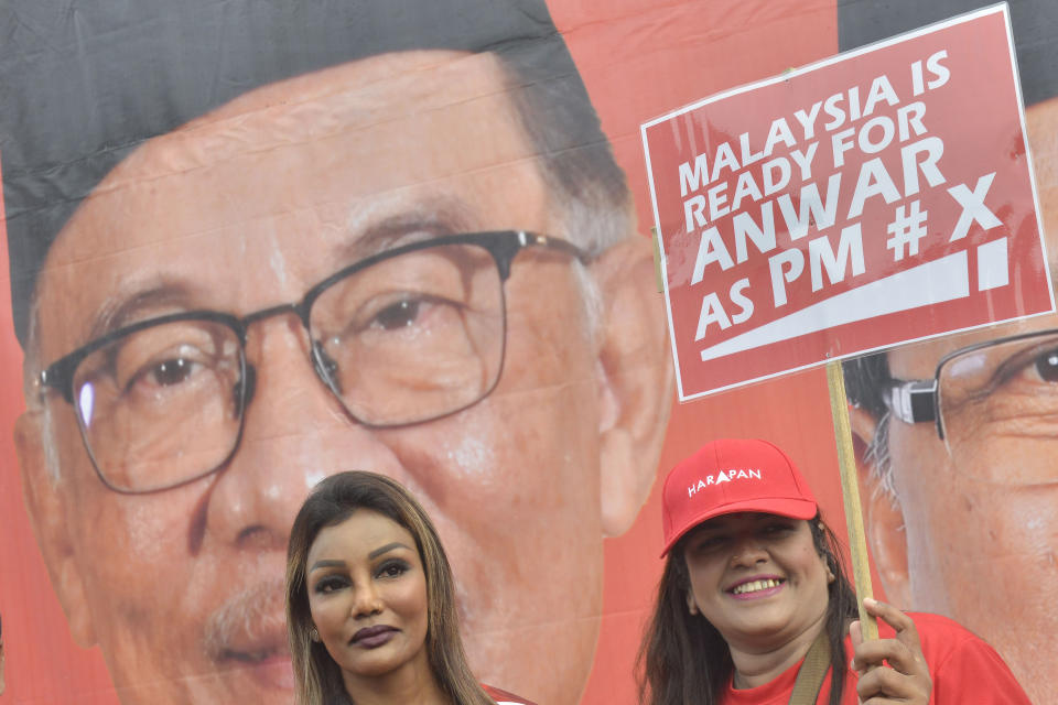 One of the supporters for Malaysian opposition leader Anwar Ibrahim holds up a sign for him outside a nomination center for the upcoming general election in Tambun, Malaysia, Saturday, Nov. 5, 2022. Campaigning for Malaysia’s general elections formally started Saturday, in a highly competitive race that will see the world’s longest-serving coalition seeking to regain its dominance four years after a shocking electoral loss. (AP Photo/JohnShen Lee)