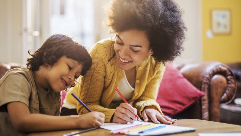 Smiling mother and son coloring together. Multiple studies have shown coloring can affect your mood. 