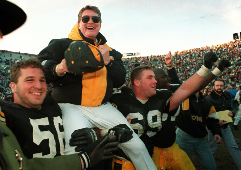 ** FILE ** Iowa football coach Hayden Fry is carried off the field after his team defeated Minnesota giving him his 200th career victory in this Nov. 20, 1993 file photo in Iowa City, Iowa. Fry, who retired after the 1998 season, was selected Monday, March 24, 2003, to the College Football Hall of Fame. (AP Photo/Charlie Neibergall)