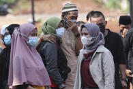 Family members mourn during a burial at the special section of Jombang Public Cemetery reserved for those who died of COVID-19, in Tangerang, on the outskirts of Jakarta, Indonesia, Wednesday, Aug. 4, 2021. Indonesia surpassed 100,000 confirmed COVID-19 deaths on Wednesday, a grim milestone in a country struggling with its worst pandemic wave fueled by the delta variant, amid concerns the actual figure could be much higher. (AP Photo/Tatan Syuflana)